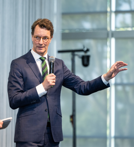 Man sieht NRW-Ministerpr&auml;sident Hendrik W&uuml;st,einen Mann mit braunen Haaren und Brille im Anzug, wie er vor einem Mikrofon steht.