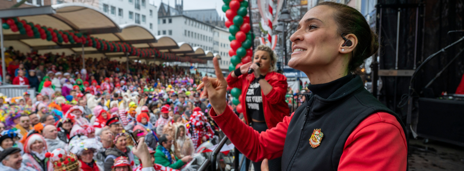 Bildcollage; unten rechts: ein Clown und eine Frau mit dunklen Haaren; Mitte rechts: Männer werfen Kamelle von einem Karnevalswagen; Mitte rechts: Mensch in einem Hühnerkostüm im Rollstuhl: rechts: eine Gebärdendolmetscherin; Bildschrift: "Karneval für alle".