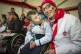 Ein als FC Köln-Fan verkleideter Mann und ein Junge im Rollstuhl.