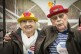 Eine ältere Frau und ein älterer Mann. Beide tragen Ringelshirts und bunte Hüte.