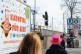 Eine Person mit einem pinkfarbenen Hut läuft an einem Plakat der LVR-Initiative 