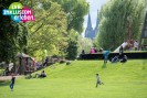 Blick in den Rheinpark, in dem einige Menschen auf der Wiese sitzen oder gehen, im Hintergrund der Dom. Oben links befindet sich das "Inklusion erleben" Logo des LVR.