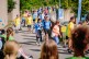 Eine Gruppe von Jugendlichen läuft eine Straße entlang. Die meisten tragen blaue oder gelbe T-Shirts. 