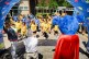 Auf einem Schulhof stehen Schülerinnen und Schüler in gelben und blauen T-Shirts.